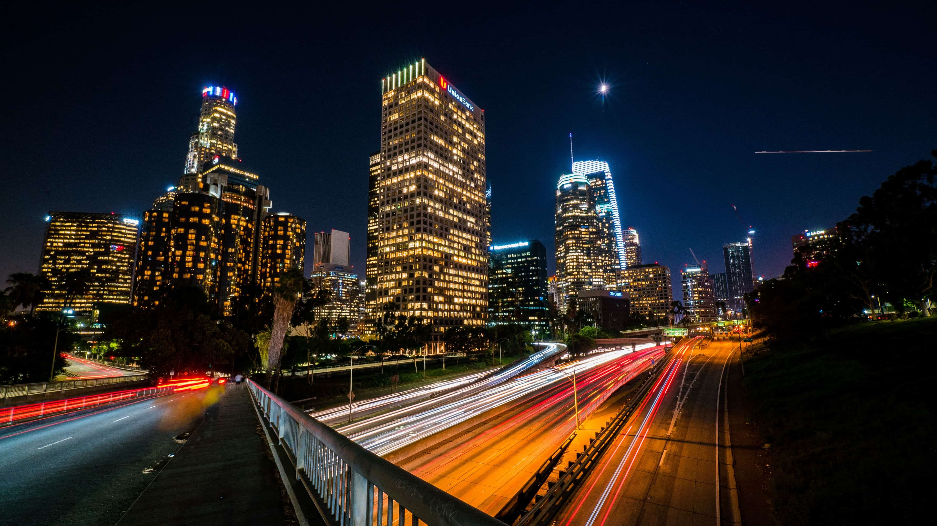Night view of downtown Los Angeles with illuminated skyscrapers and traffic trails