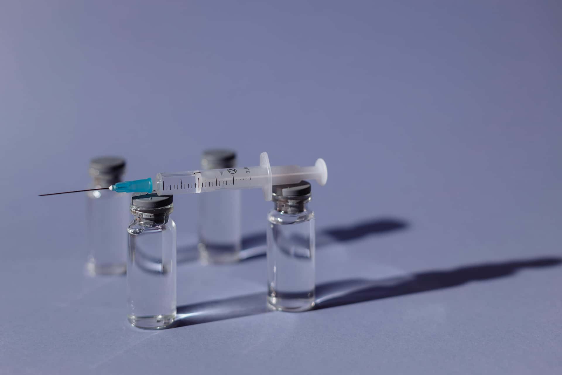 Vaccine vials and a syringe on a table