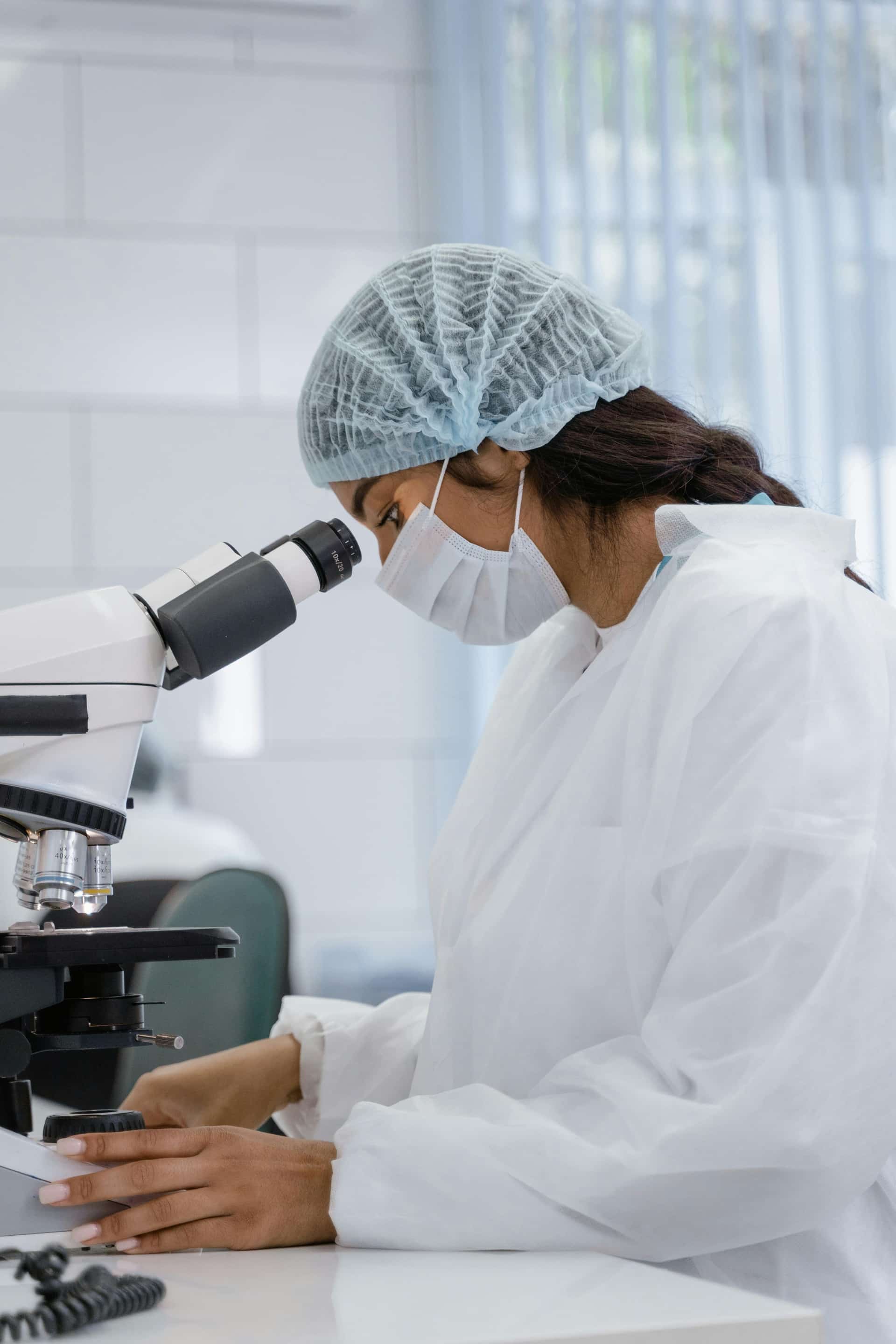 Medical technologist using a microscope in a lab
