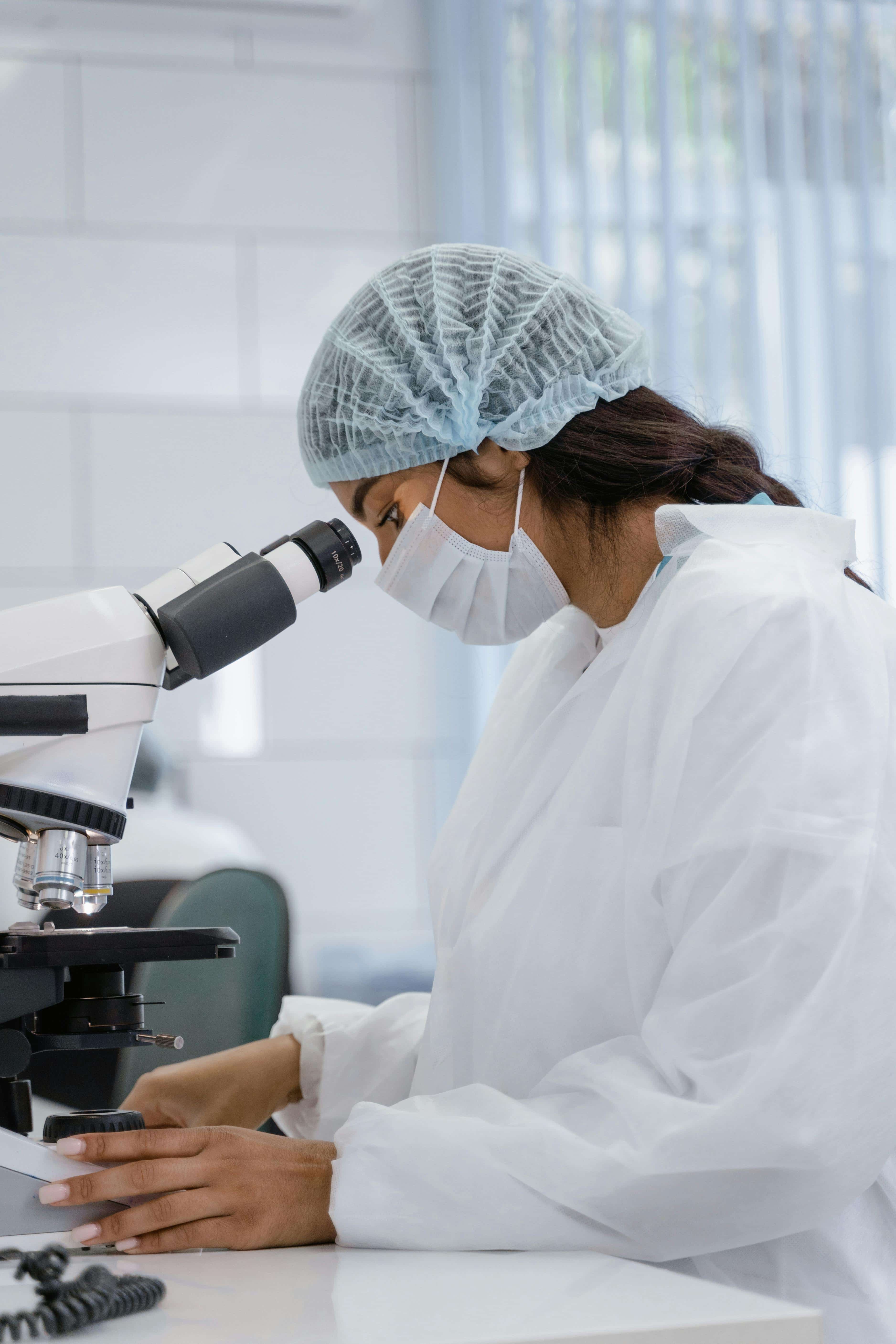 Medical technologist using a microscope in a lab