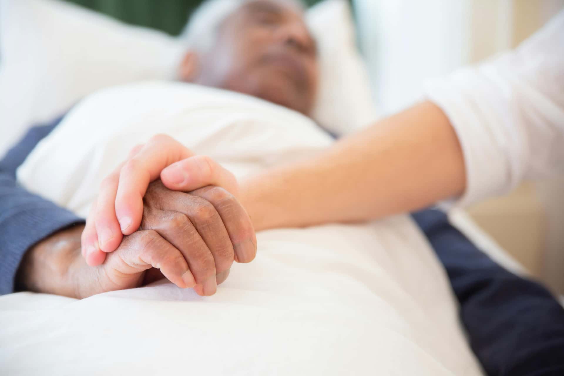 Young person holding an older person's hand