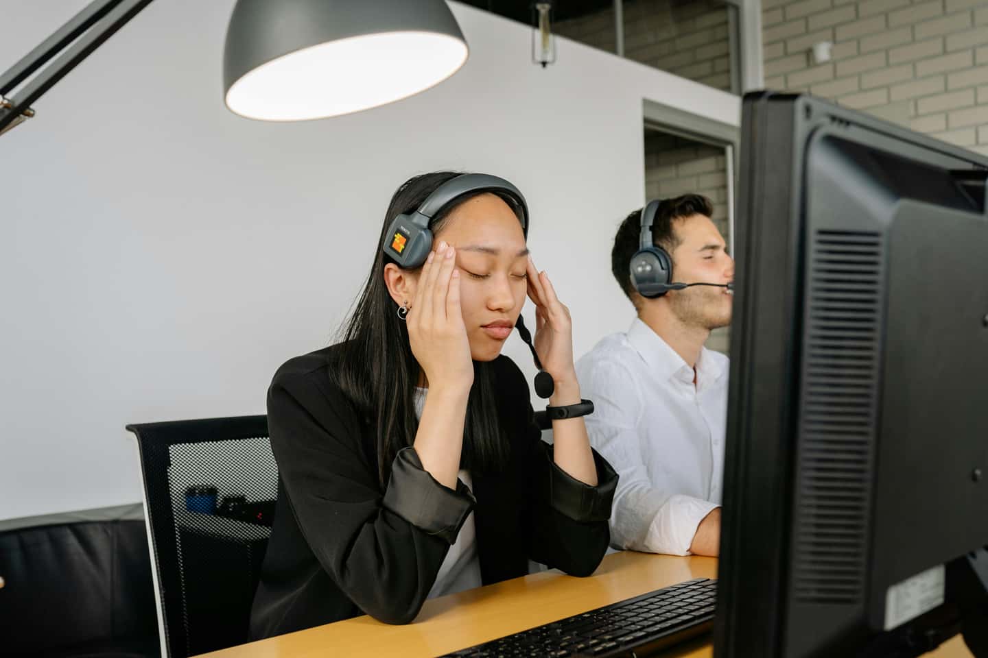 Exhausted call center worker sitting in front of a computer