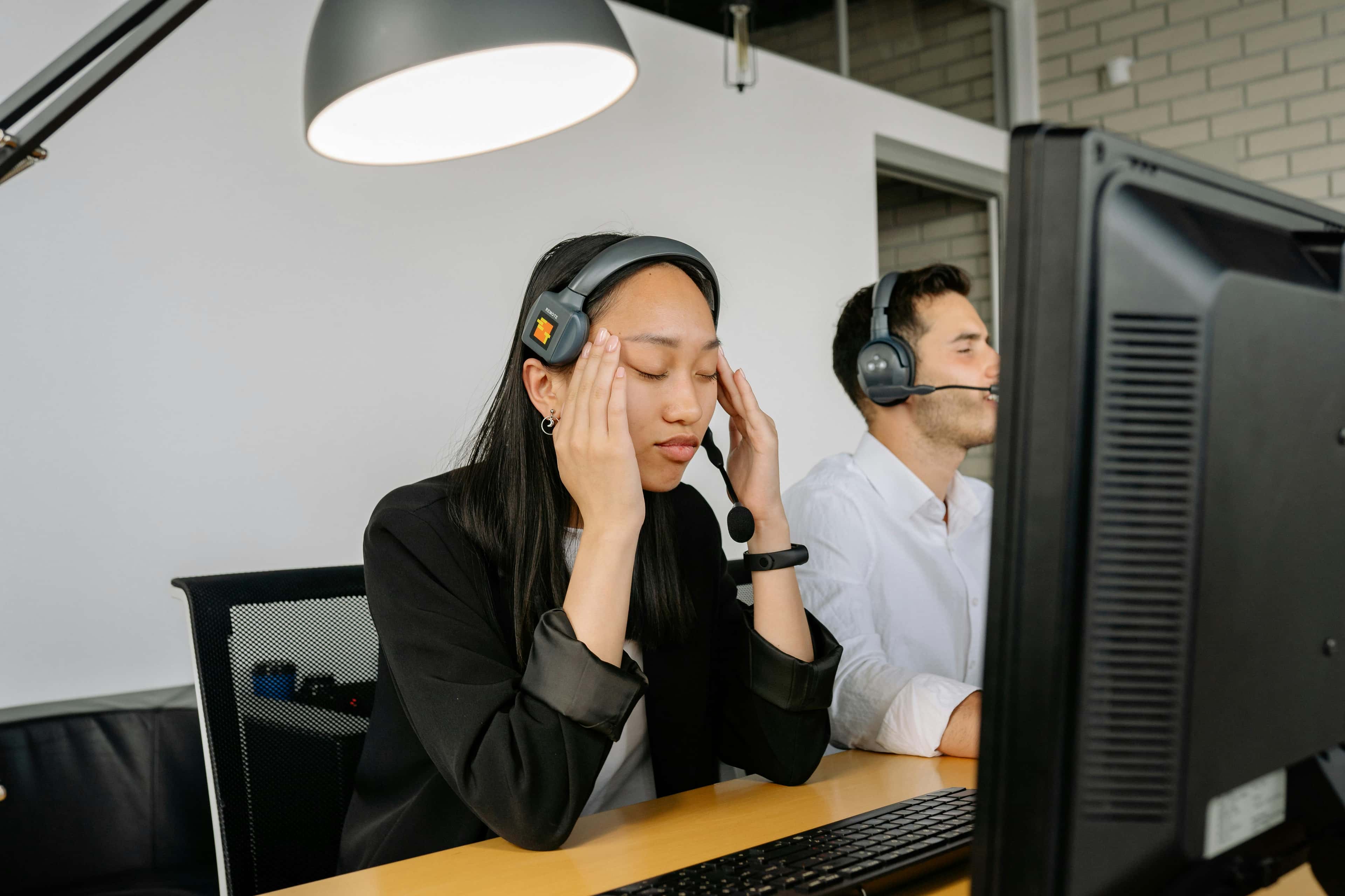 Exhausted call center worker sitting in front of a computer